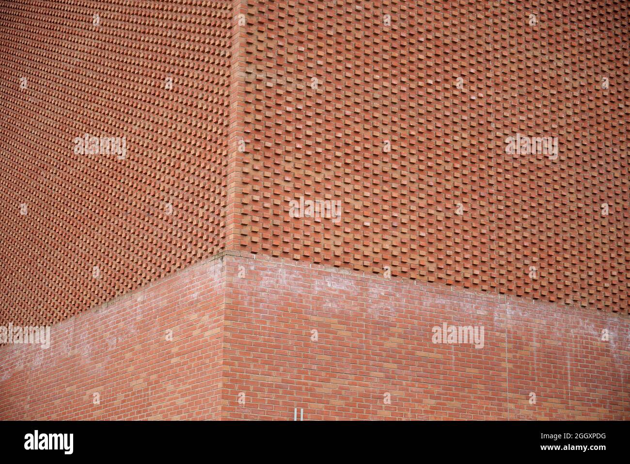 A modern red brick architectural structure with in built pattern or texture due to the positioning of the bricks. Stock Photo