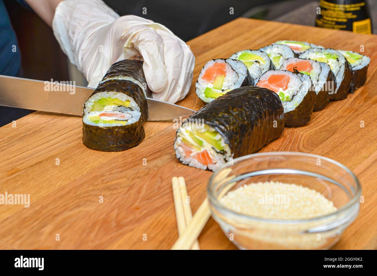 https://c8.alamy.com/comp/2GGY0K2/the-process-of-making-japanese-sushi-knife-in-hand-cuts-a-roll-close-up-on-a-wooden-board-2GGY0K2.jpg