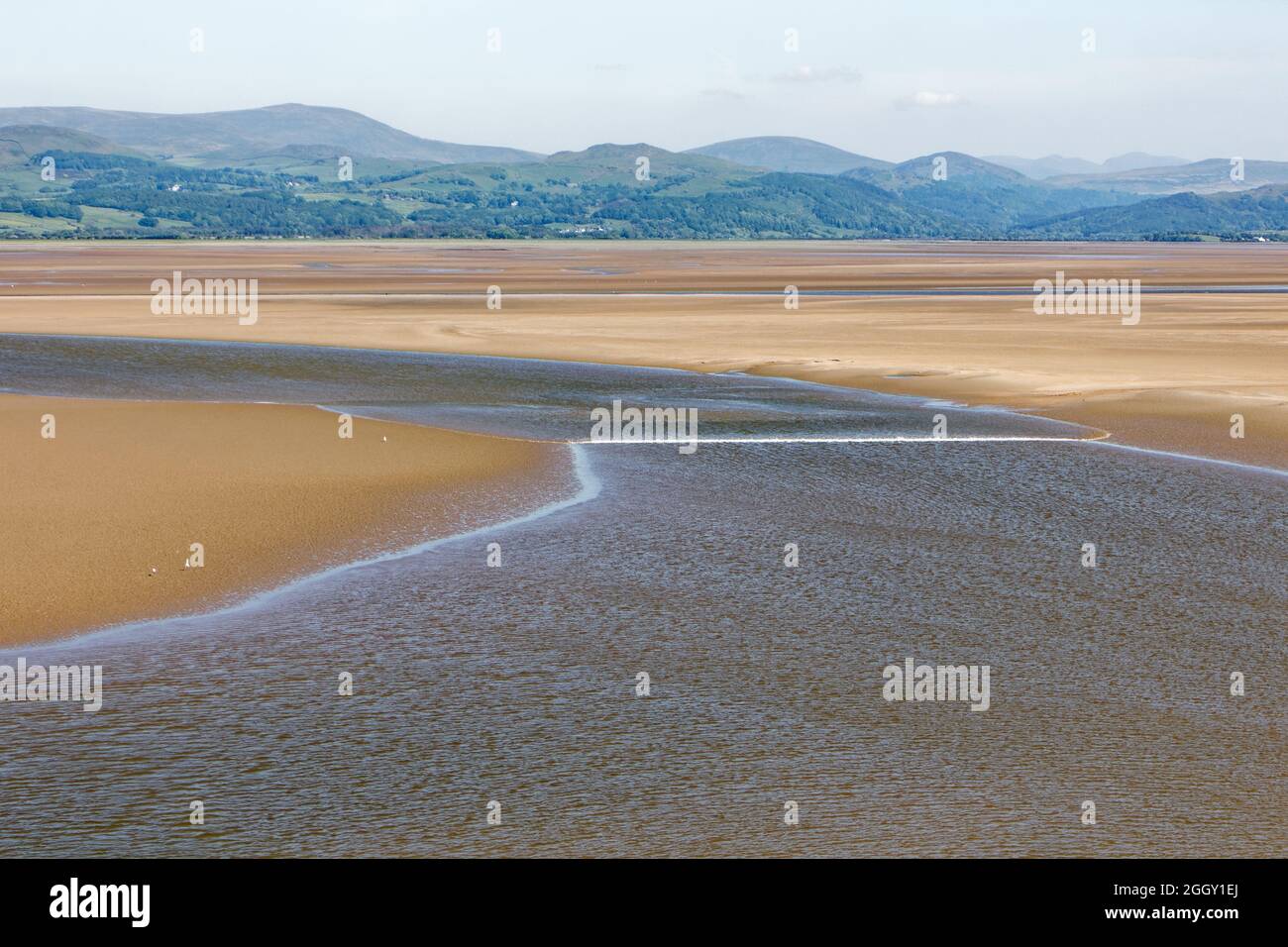 The Duddon Tidal Bore and Lake District fells viewed from Dunnerholme, a limestone promontory on the shores of the Duddon Estuary Stock Photo