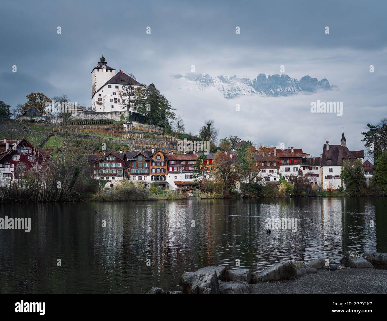 Skyline of Buchs with Werdenberg Castle, Werdenberg Lake and Alps Mountains on background - Buchs, Switzerland Stock Photo