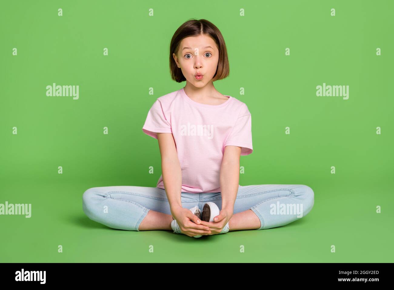 Full length photo of young attractive little girl sit floor stretching  training gym isolated over green color background Stock Photo - Alamy