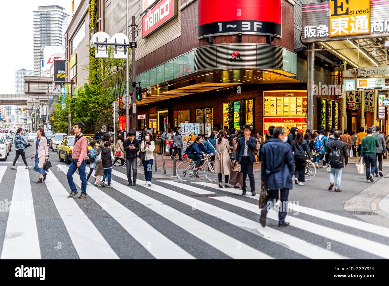 Osaka, Japan - April 13, 2019: Modern buildings road near station with traffic of candid people crossing street to famous arcade and business signs Stock Photo
