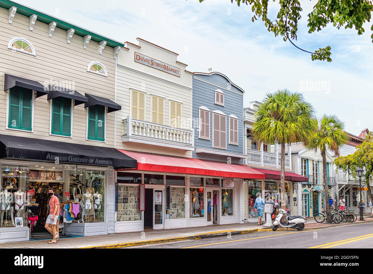 Key West, USA - January 25, 2021: Duval Street road sidewalk in Florida keys city with people walking by souvenir gift stores, art gallery shops by pa Stock Photo