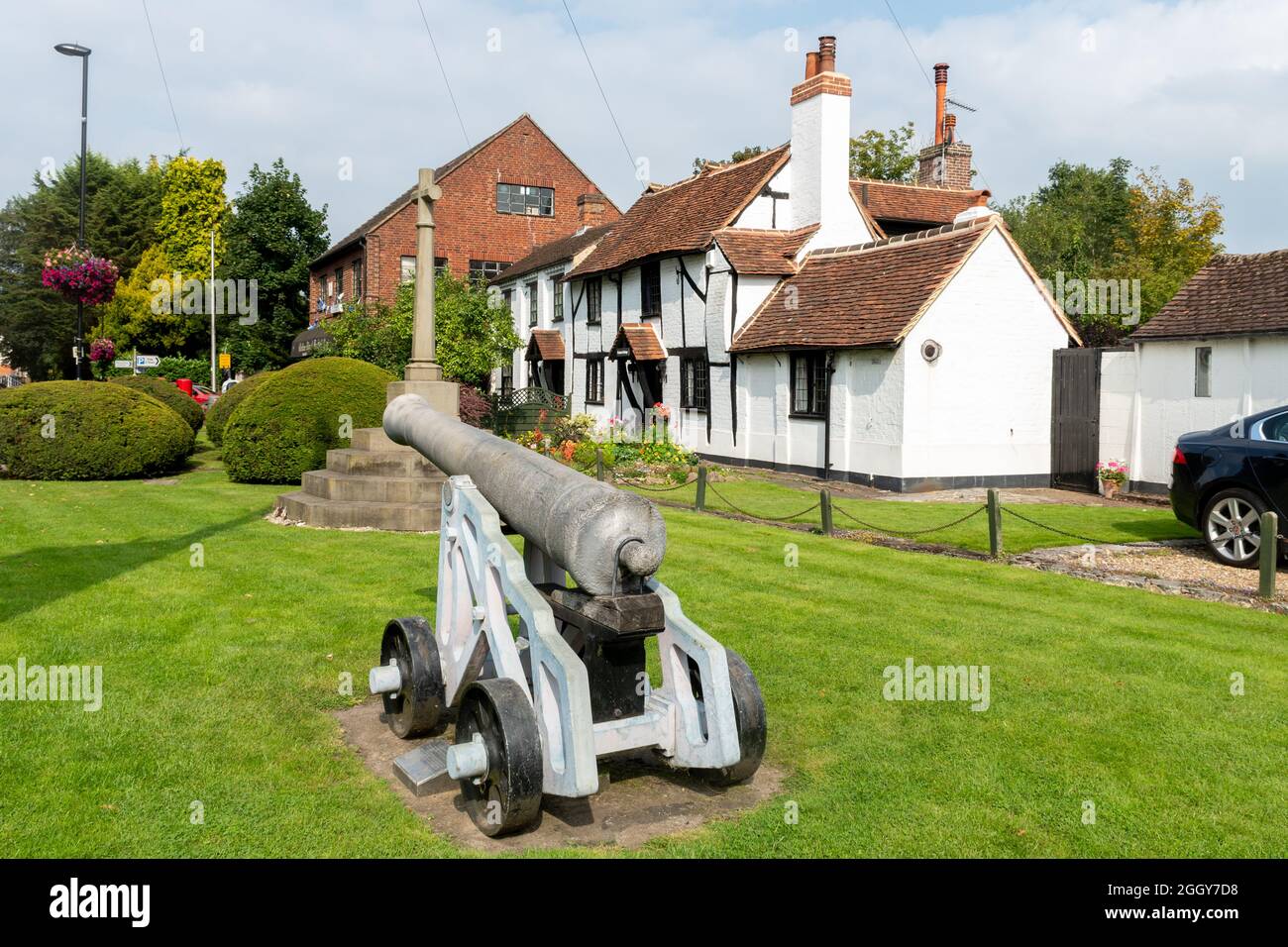 The historic cannon and war memorial in front of cottages in Chobham, a