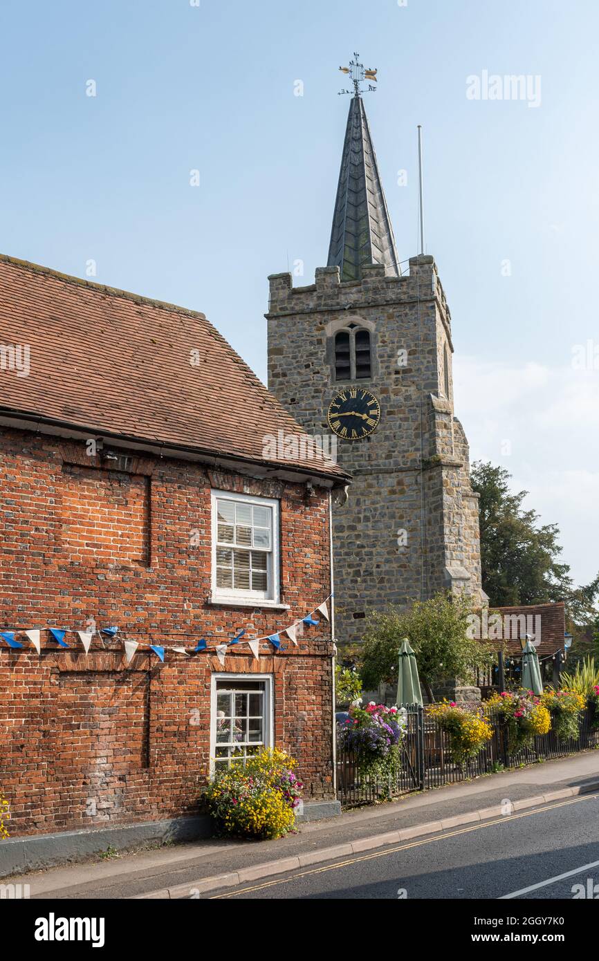 The High Street in Chobham village, Surrey, England, UK, with St Lawrence Church Stock Photo