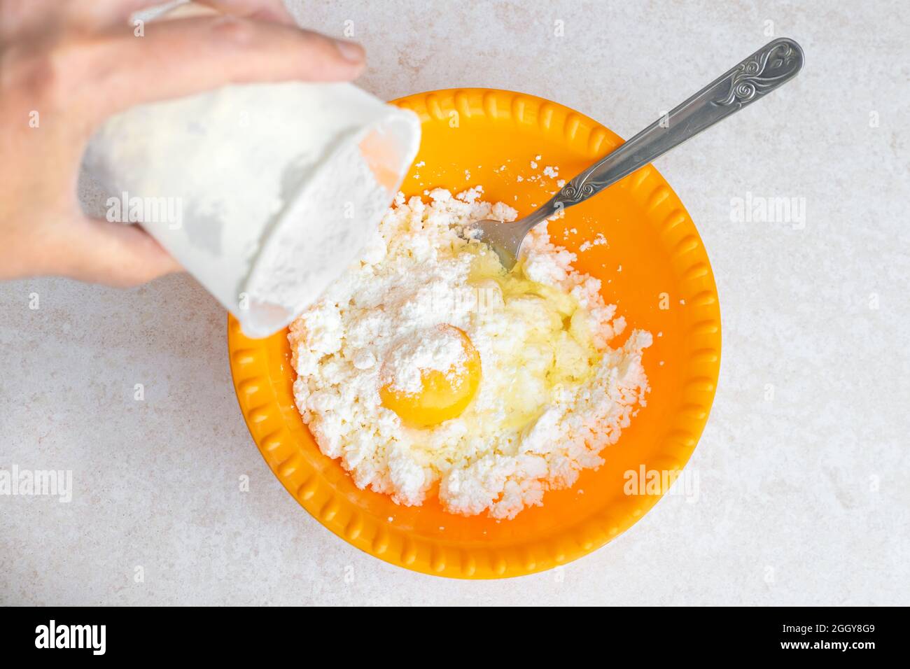 Cooking cheese cakes. Pour flour into a yellow cup with fresh cottage