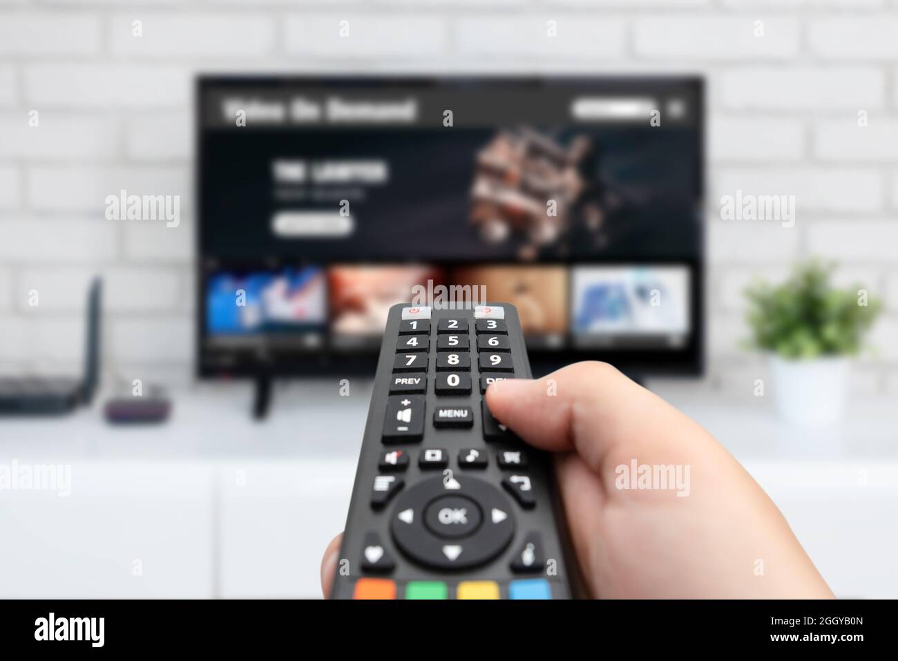 Man watching TV, remote control in hand. VOD service on TV Stock Photo