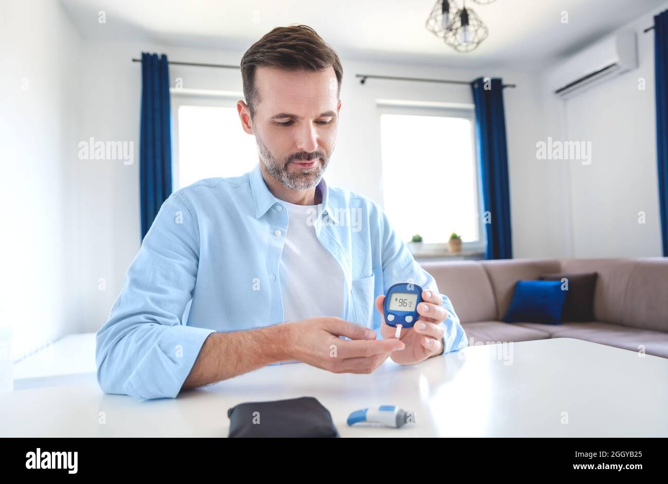 Man Using Glucometer Man measures his blood sugar. Glucometer, blood sample test, diabetes ...