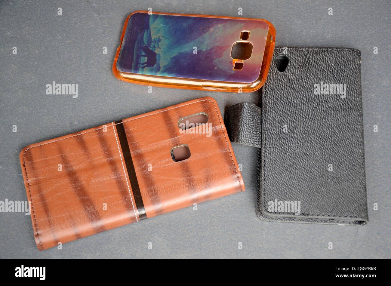 Closeup shot of three different phone cases on a marble surface Stock Photo