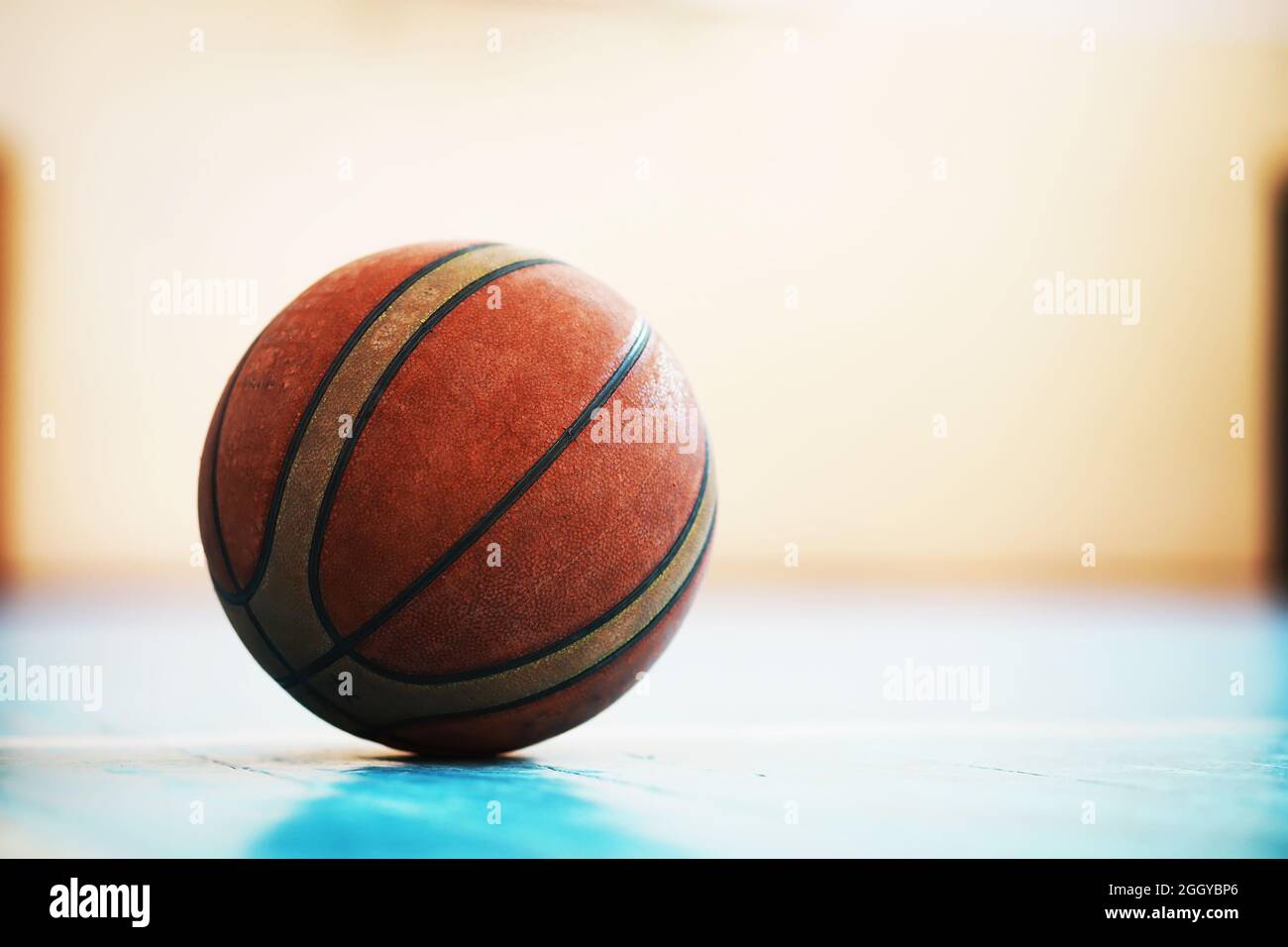 A human foot rest on the basketball on concrete floor. Photo of one