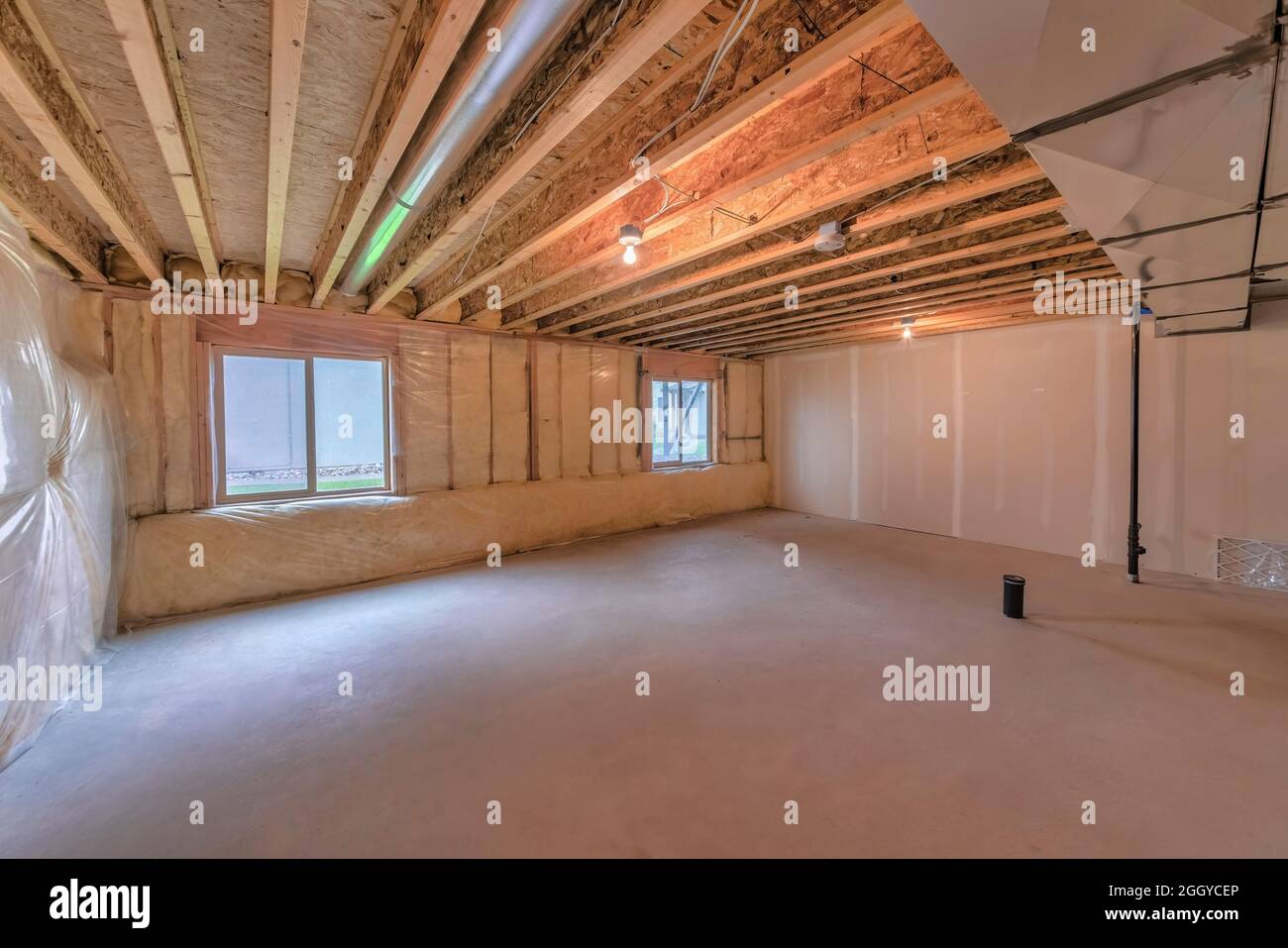 Unfinished basement with plastic vapor barrier and windows Stock Photo Alamy