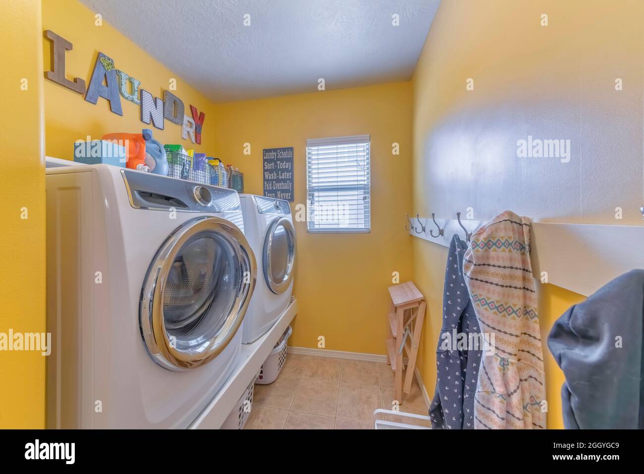 Laundry room interior with decorations on the yellow wall Stock Photo