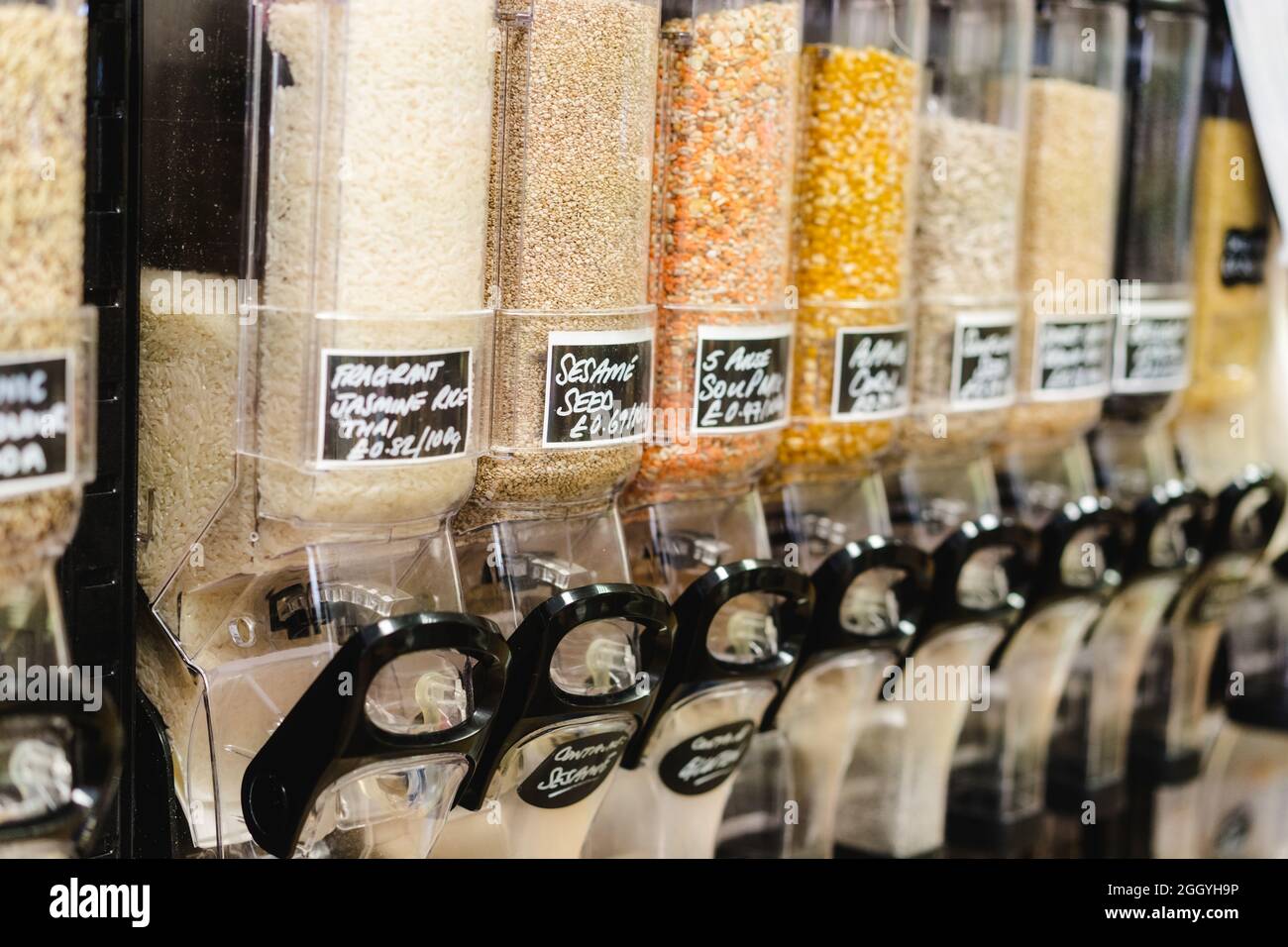Eco-friendly zero waste shop. Dispensers for cereals, nuts and grains in sustainable plastic free grocery store. Bio organic food. Shopping at small Stock Photo