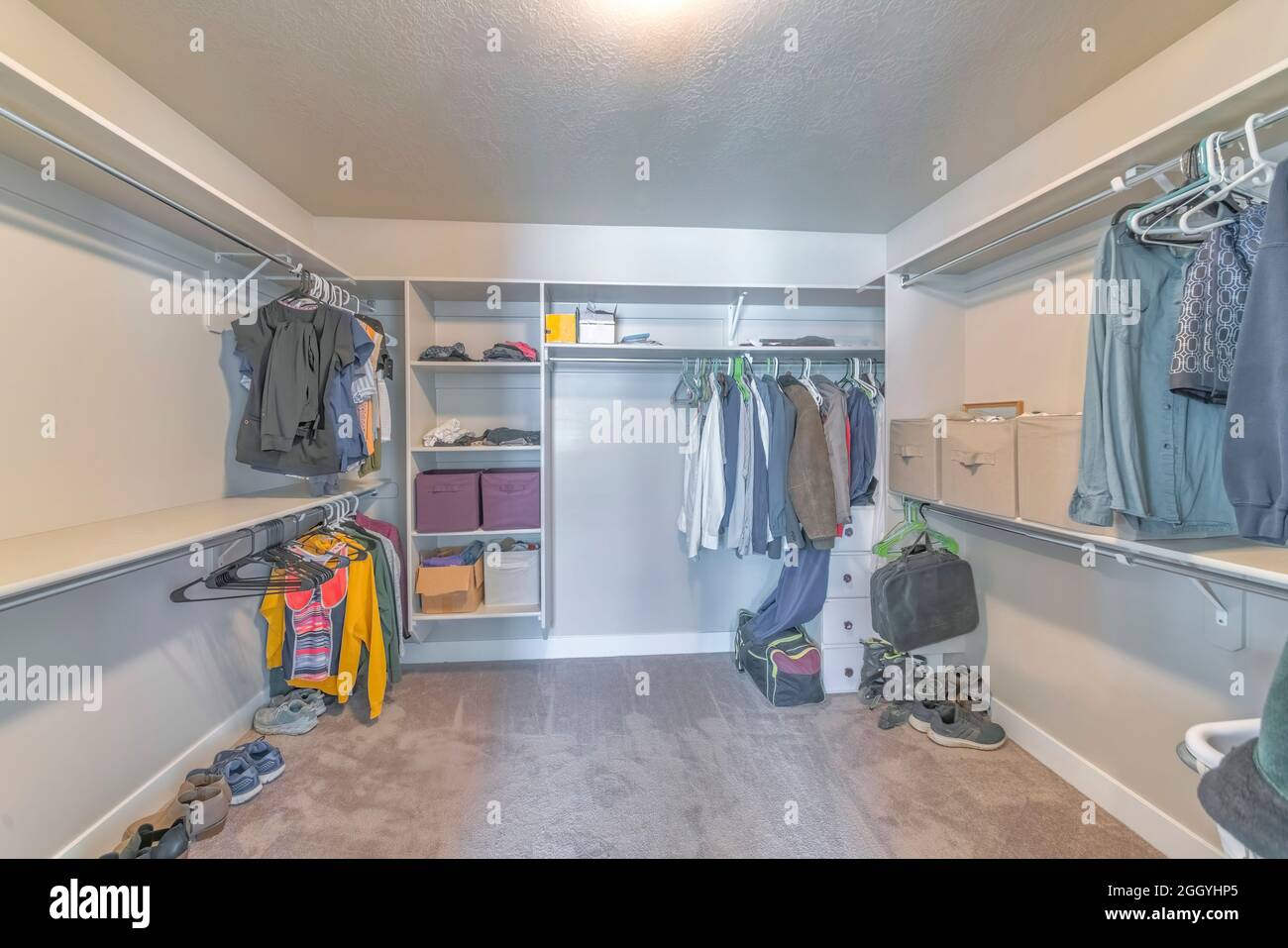 Large walk-in closet with a few clothes on the open shelving unit Stock Photo