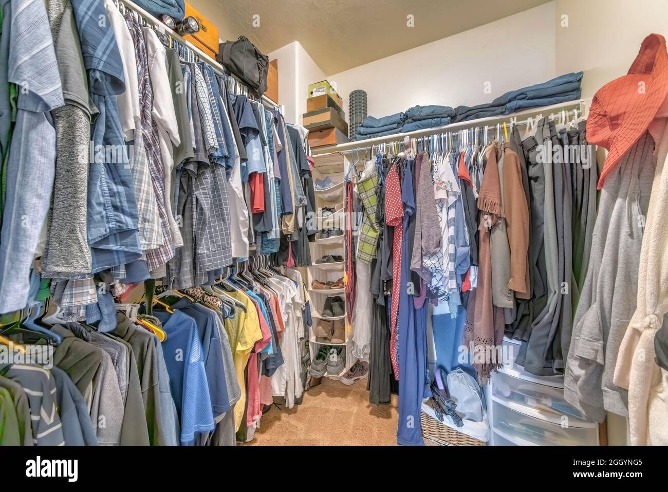 Walk-in closet with hanging linen shoe rack and clothes Stock Photo