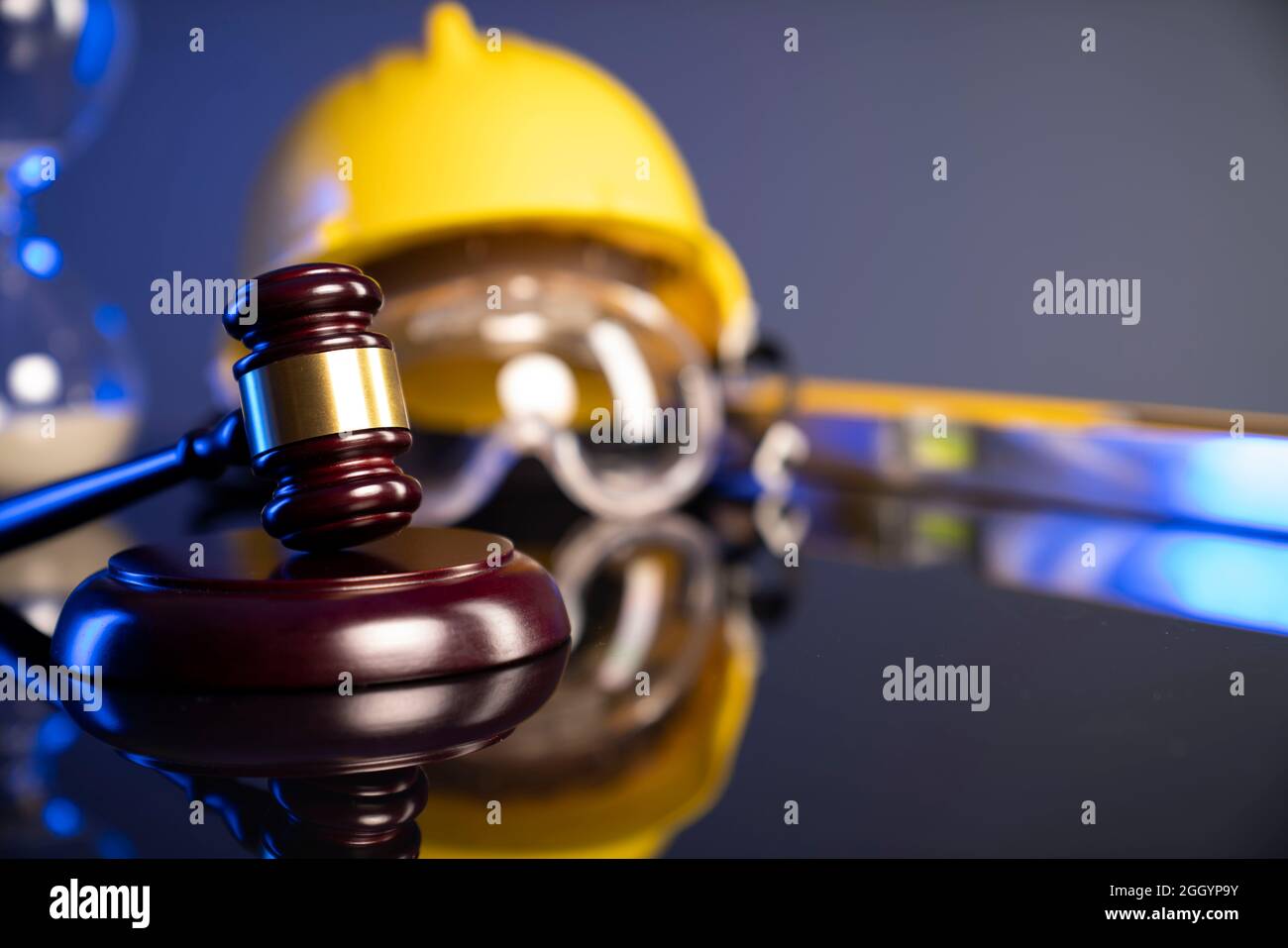 Construction law concept. Helmet and judge’s gavel on the gray