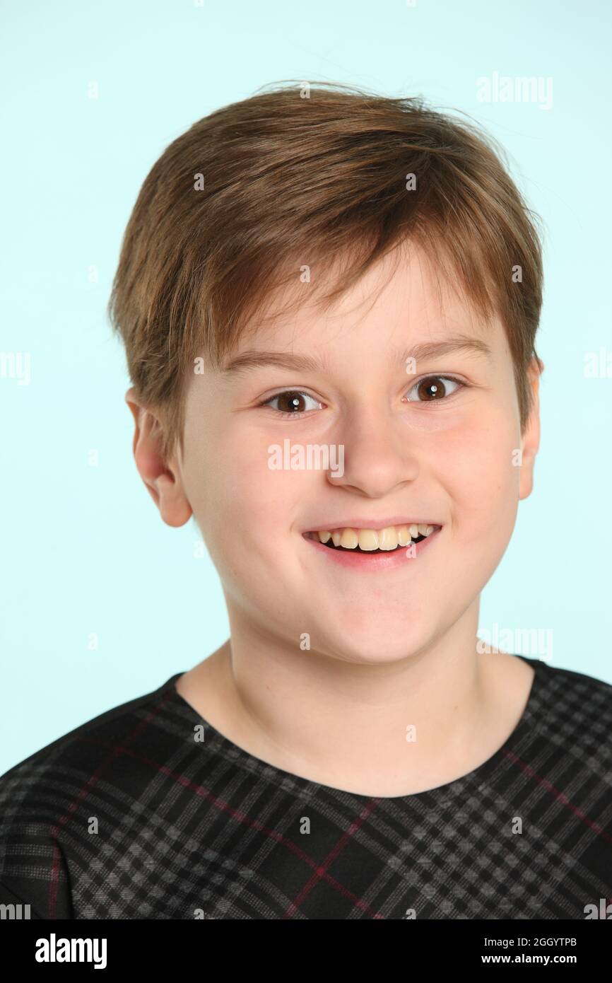 Cheerful and mischievous teenage boy smiling in a close-up portrait ...