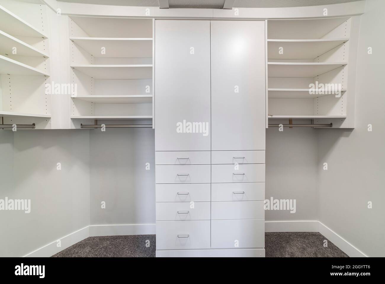 https://c8.alamy.com/comp/2GGYTT6/white-windowless-walk-in-closet-with-tall-cabinet-in-the-middle-2GGYTT6.jpg