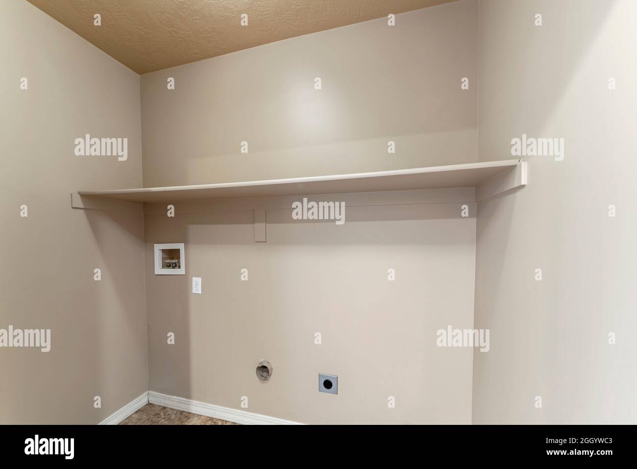 Empty laundry room interior with wall mounted shelf Stock Photo