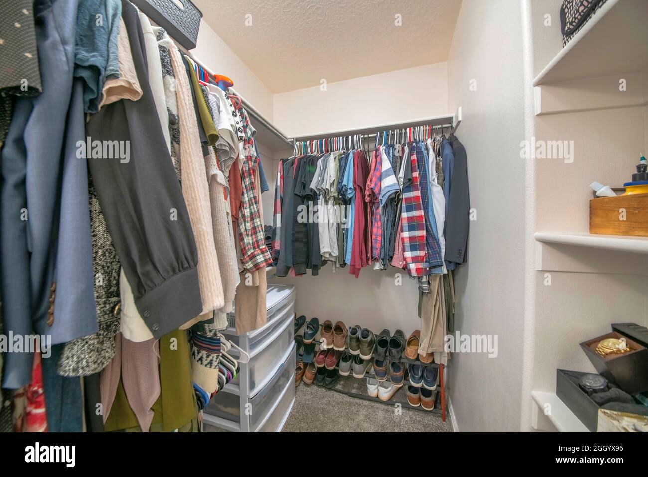 Hanging clothes on a metal rods inside a walk-in closet Stock Photo