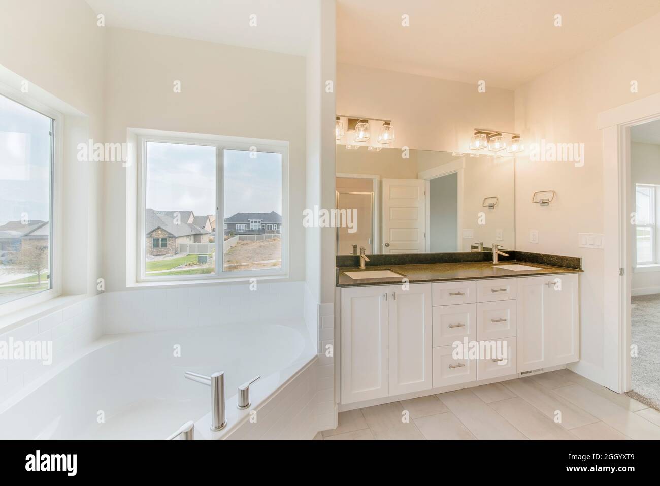 Contemporary masters bathroom with sliding windows in all white Stock