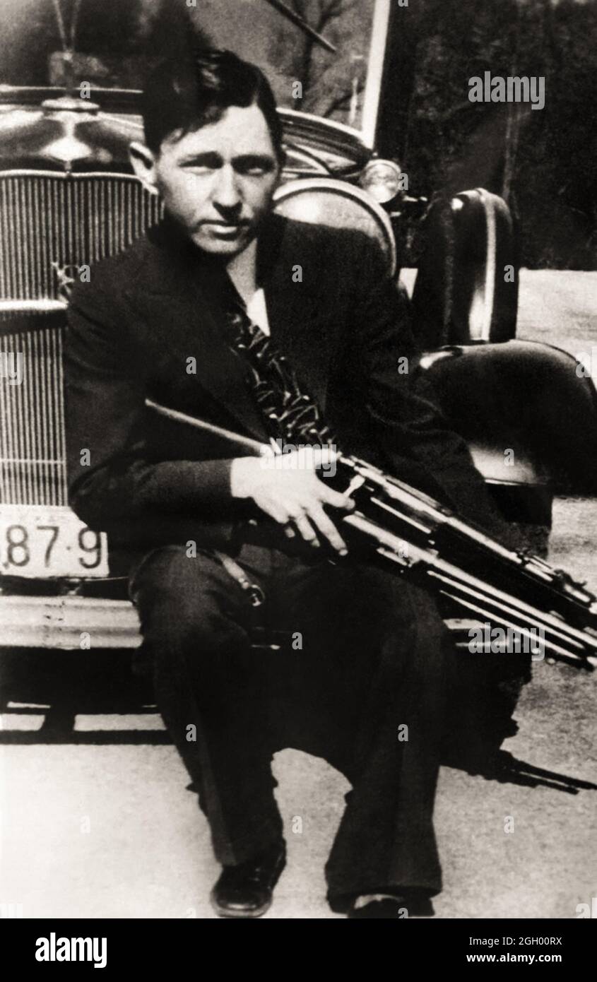 1934 , USA : Clyde Barrow with a gun . The famous gangsterns couple  BONNIE PARKER  ( 1910 - 1934 ) and CLYDE BARROW ( 1909 - 1934 ). Contrary to popular belief the two never married. They were in a long standing relationship. Posing in front of a 1932 Ford V8 automobile. Recovered from Bonnie and Clyde after their deaths on May 23, 1934 . Unknown photographer .- OUTLAWS - KILLER - ASSASSINO - delinquente - criminalità organizzata  - GANGSTERN - Bos - CRONACA NERA - CRIMINALE  ---  Archivio GBB Stock Photo