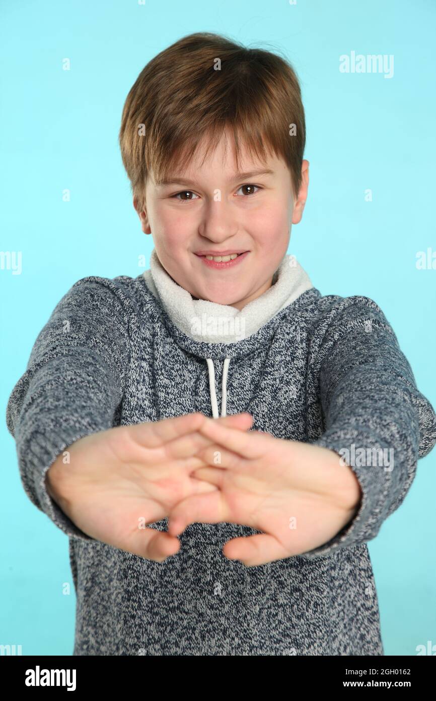 In the portrait, a handsome teenage boy smiles and stretches, rejoices