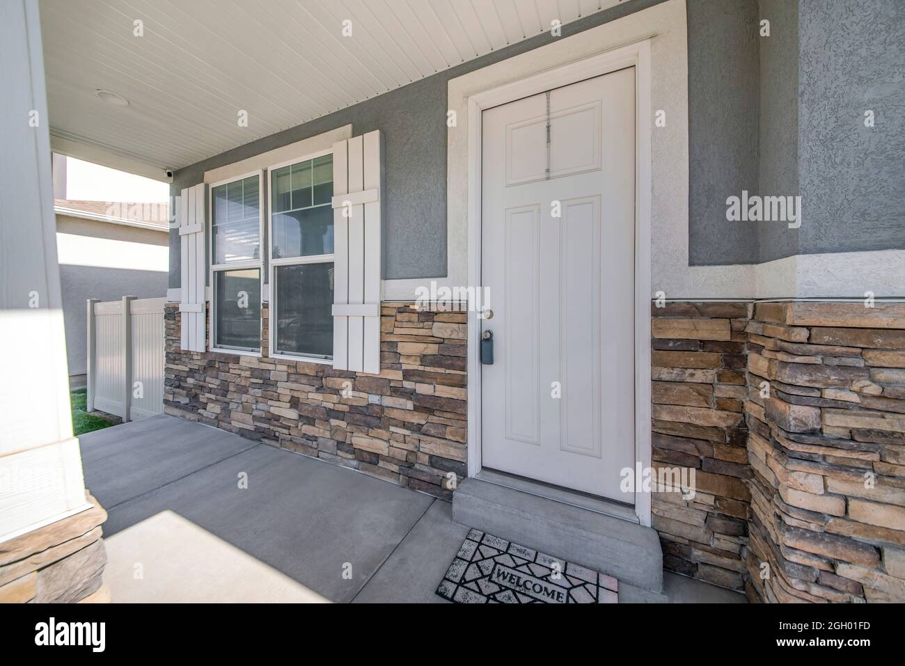 Exterior of a house with gray and stone veneer siding Stock Photo