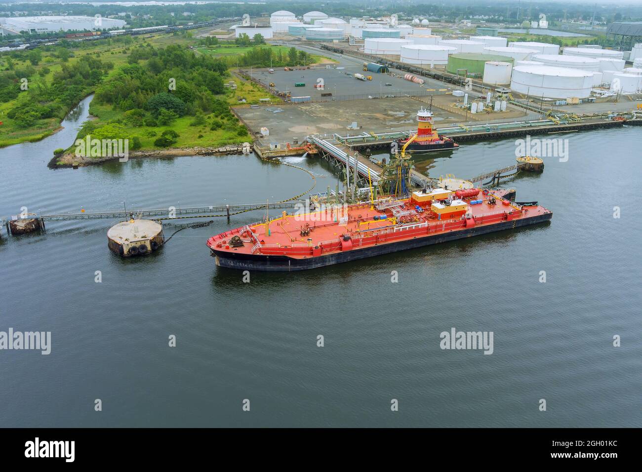 Aerial view of industrial cargo oil tanker, on pipes safety system in crude oil storage terminal Stock Photo