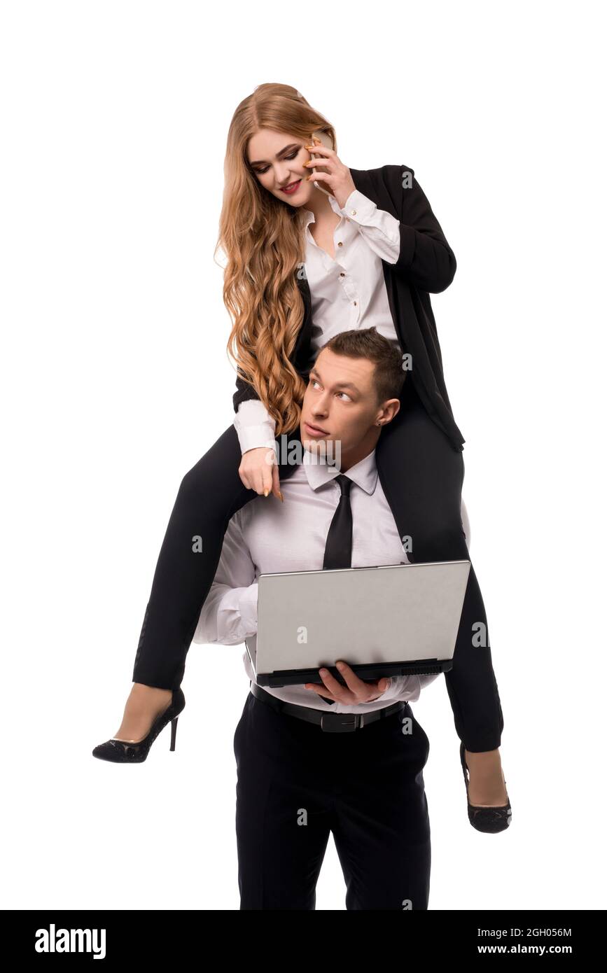 Male entrepreneur carrying female colleague on shoulders Stock Photo