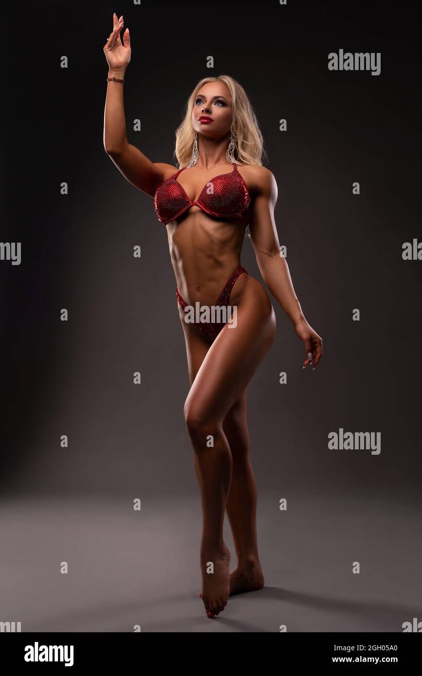 Powerful blond female model with glittering bikini in dark Stock Photo
