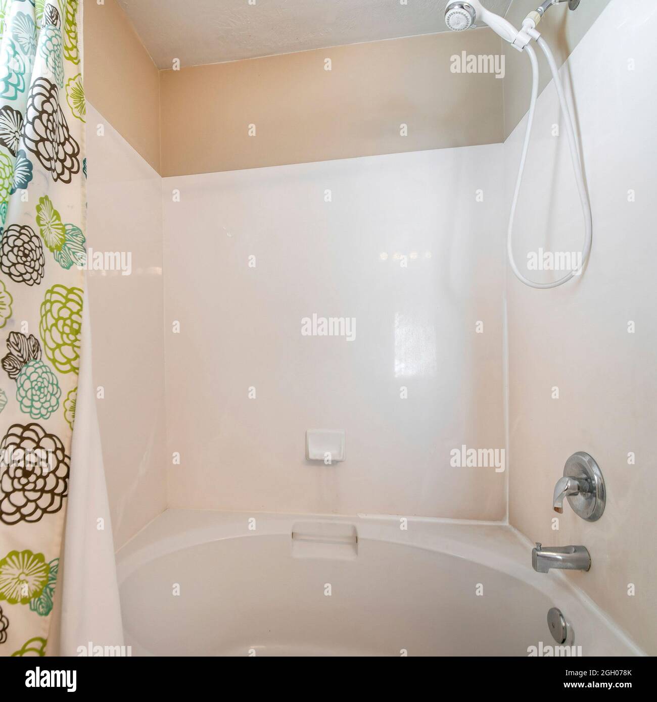 Square frame Bathtub and shower combo set in a bathroom with a shower curtain with floral design