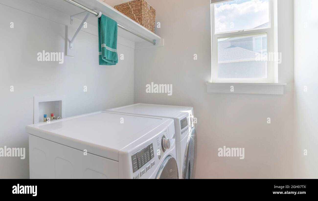 Pano Clean laundry room with one window and two laundry machines Stock