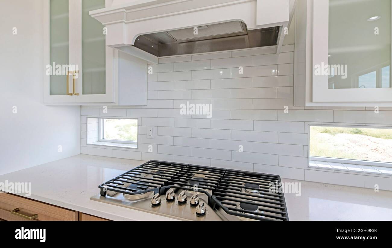 https://c8.alamy.com/comp/2GH08GR/pano-white-kitchen-counter-with-built-in-gas-cooktop-with-griddle-in-stainless-steel-2GH08GR.jpg