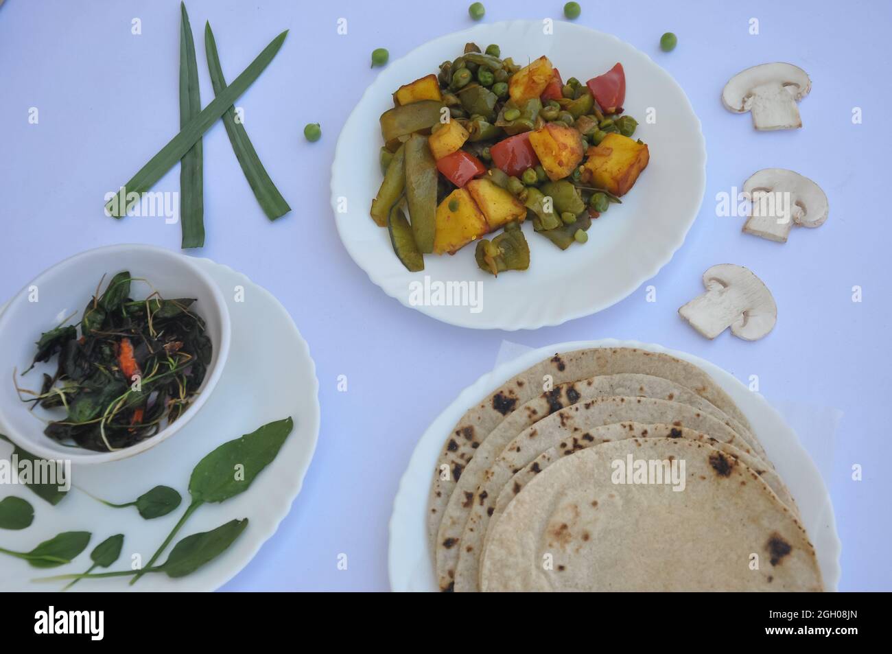 Indian Food: Flat lay of matar paneer mix veg, saag (greens) and roti (chapati) isolated over white background Stock Photo