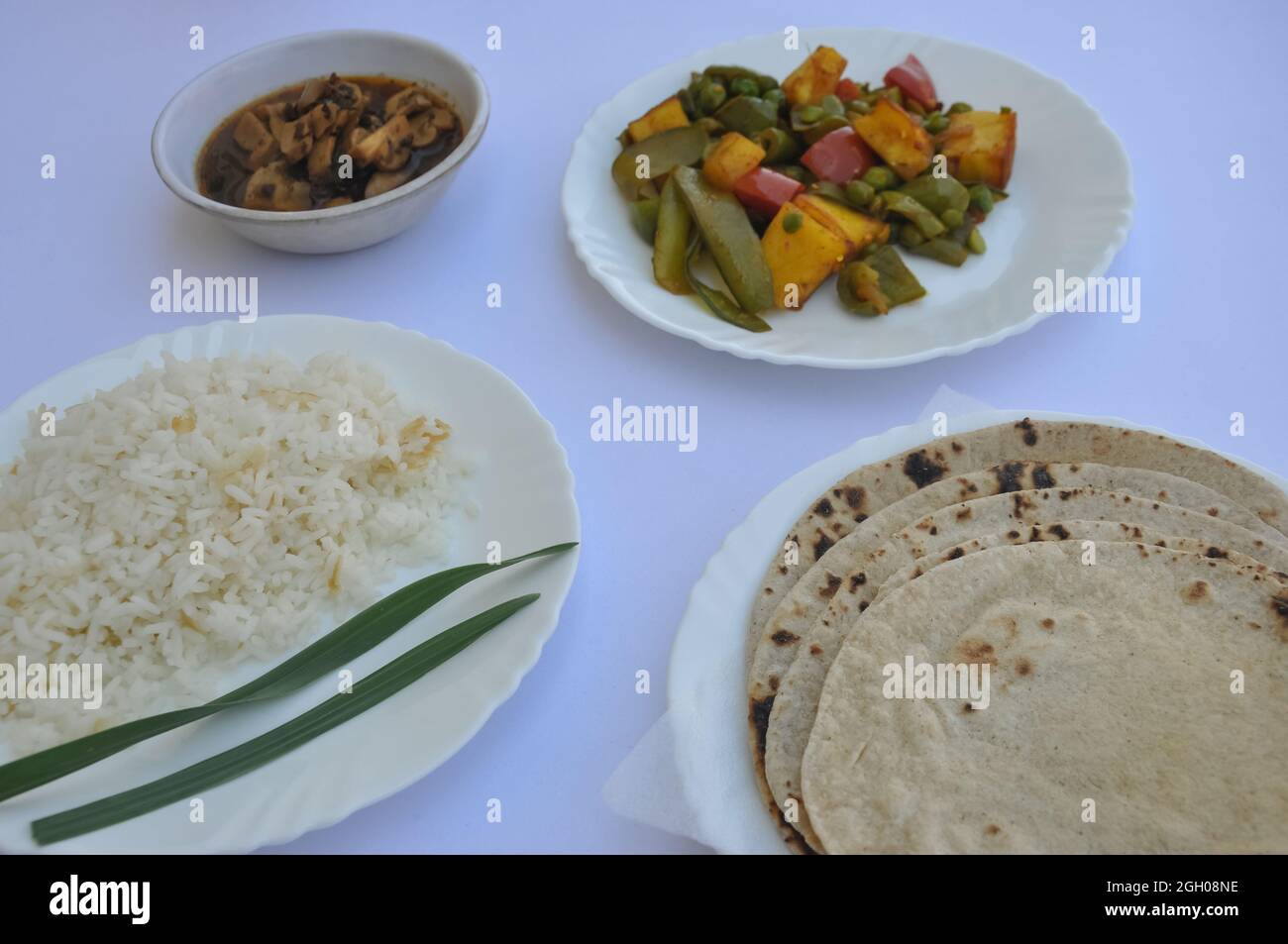 Closeup of matar paneer veg, mashroom soup, roti (chapati) and rice (Indian food) isolated over white background Stock Photo