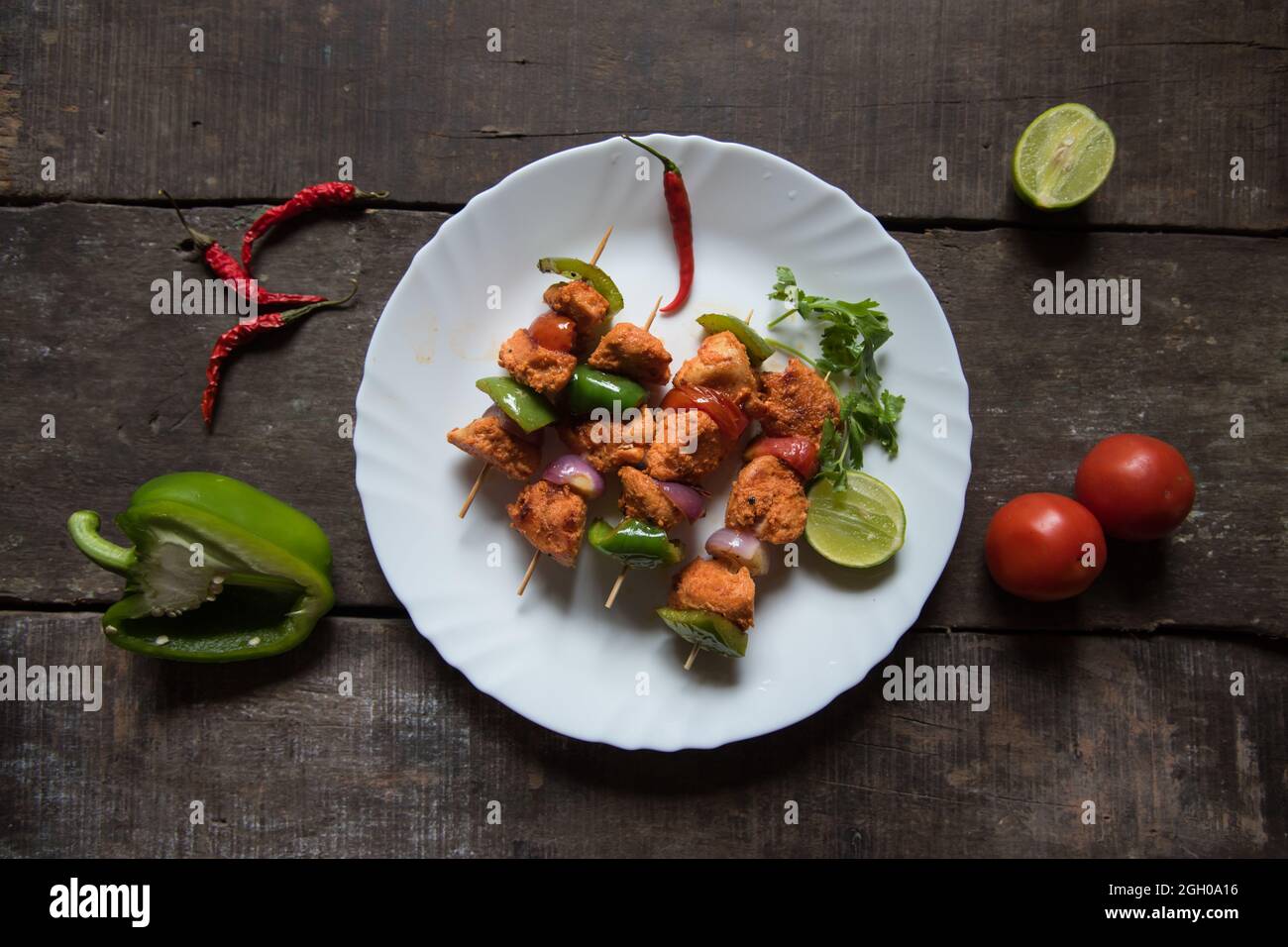 Chicken kebabs or doners grilled with saute vegetables in a white plate. Top view. Stock Photo