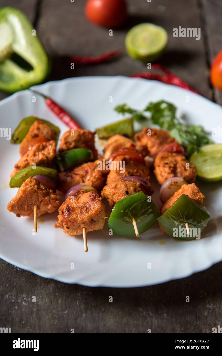 Chicken kebabs or doners grilled with saute vegetables in a white plate. Stock Photo
