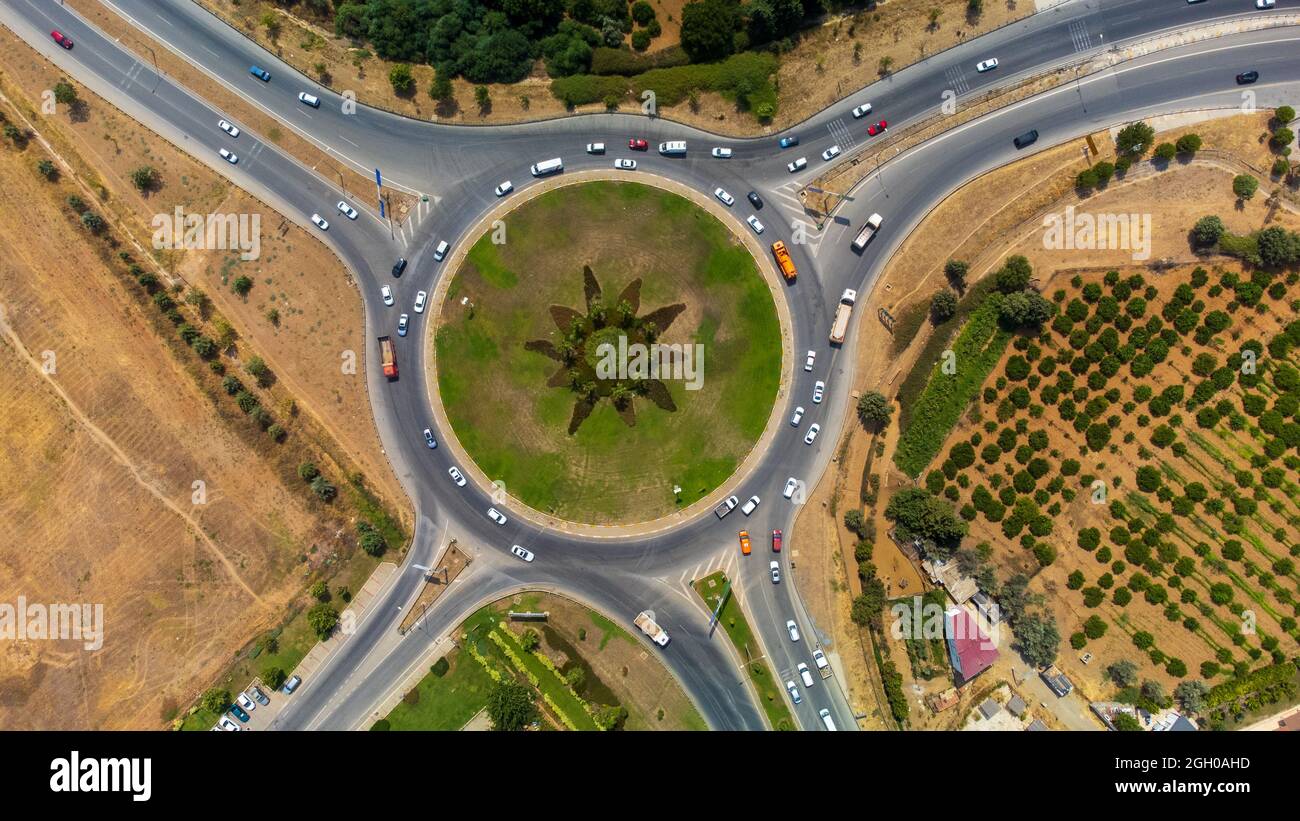 Aerial view of the cars driving on the roundabout road in the ...