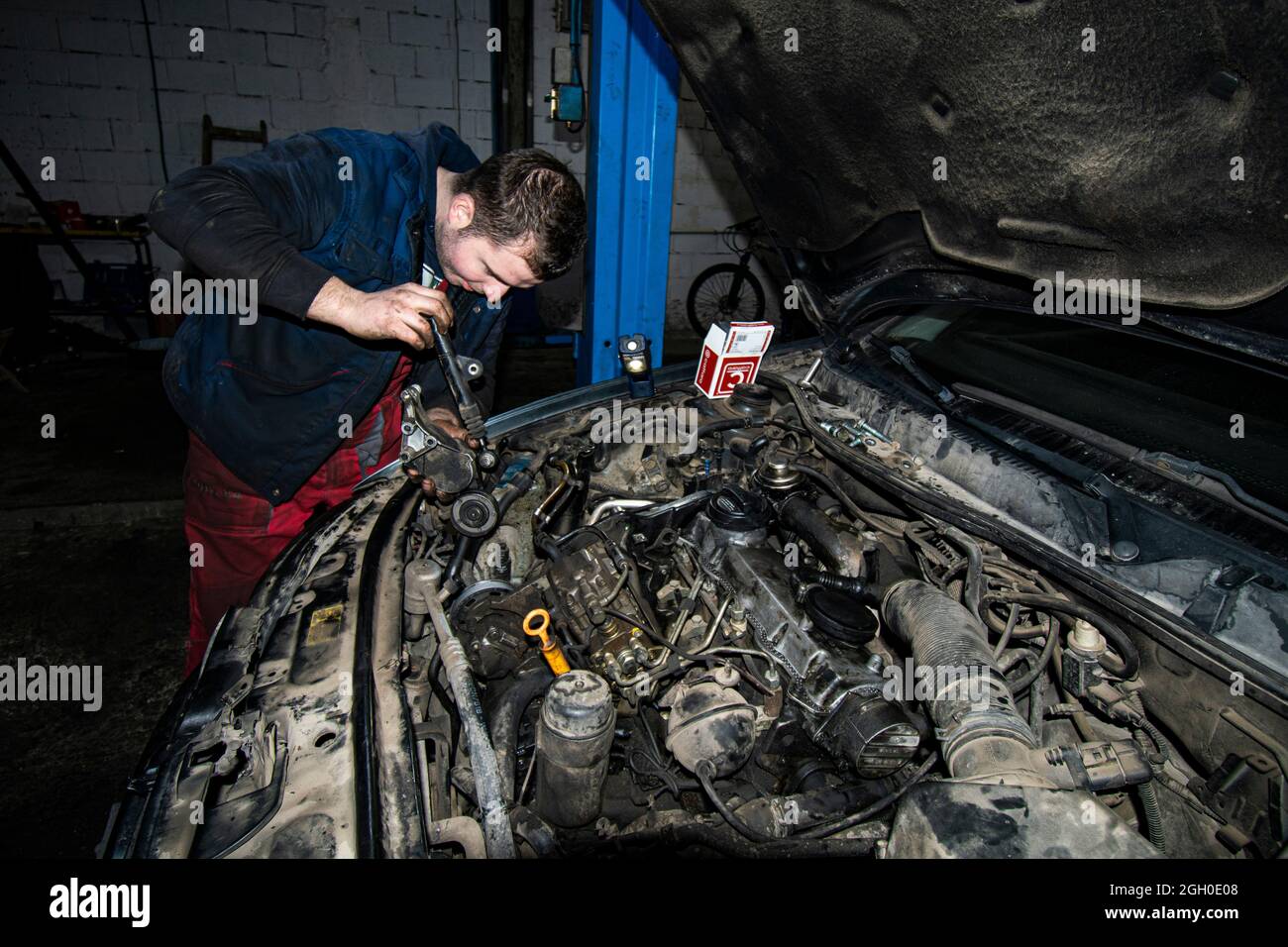 Open real car engines in the repair phase in a car mechanic shop. The mechanic repairs the