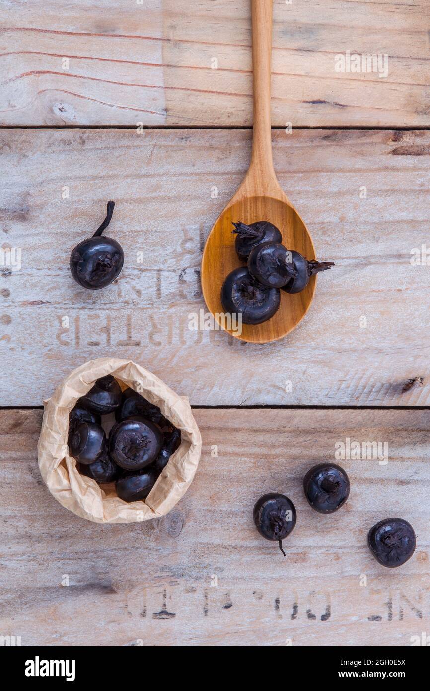 Chinese water chestnut ,water nut or Matai roots in wooden spoon and paper bag on rustic old wooden background. Stock Photo