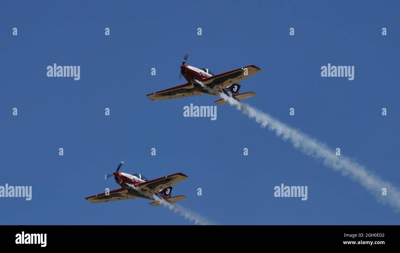 Ferrara Italy JUNE, 27, 2021 Formation of small ultra light planes in flight with smokes in sunny day with blue sky. Pioneer 300 by Alpi Aviation Stock Photo