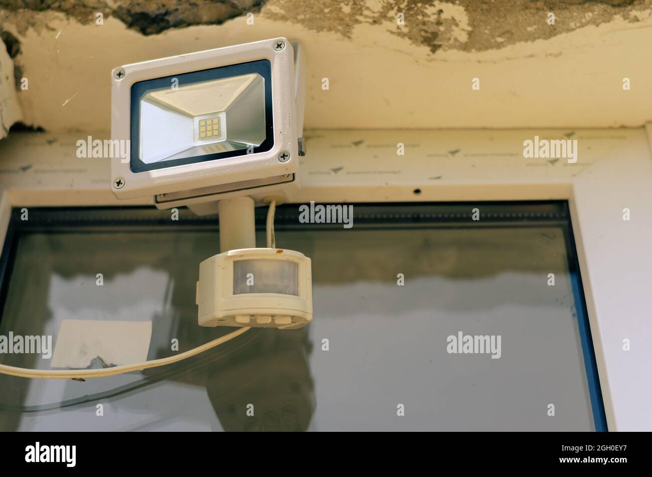 Motion sensor and LED spotlight on the wall of the building. Aut Stock Photo