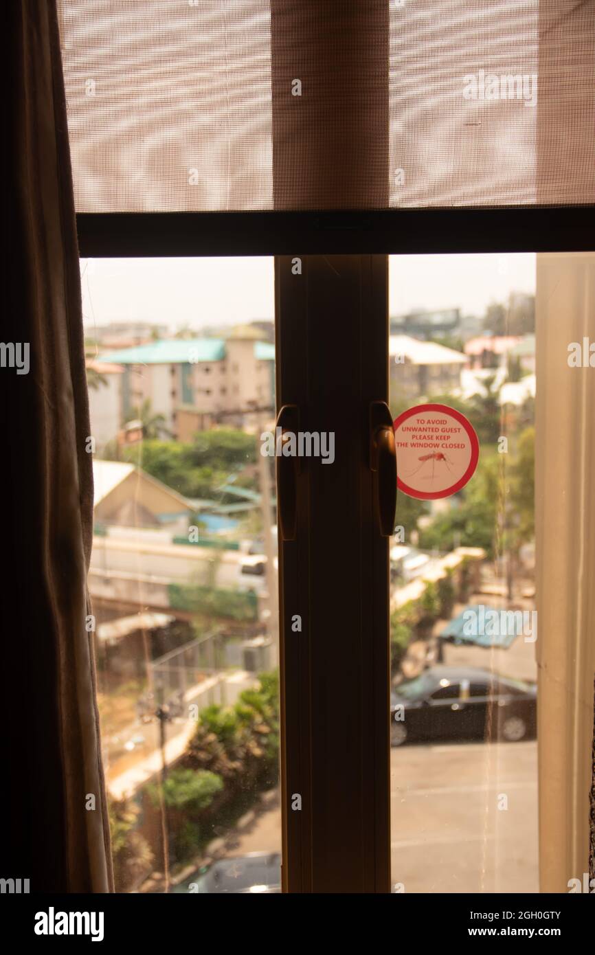 To avoid unwanted guests please keep your window closed -warning sign/sticker at the window for Mosquito and malaria prevention Stock Photo