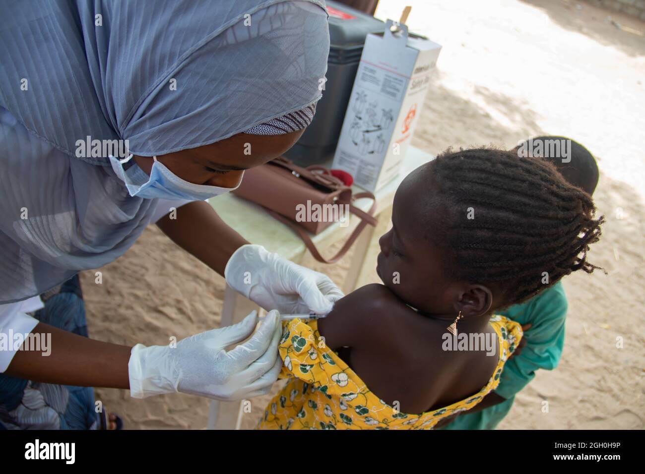 Medical worker doing routine immunization vaccination in refugee camp in Africa Stock Photo