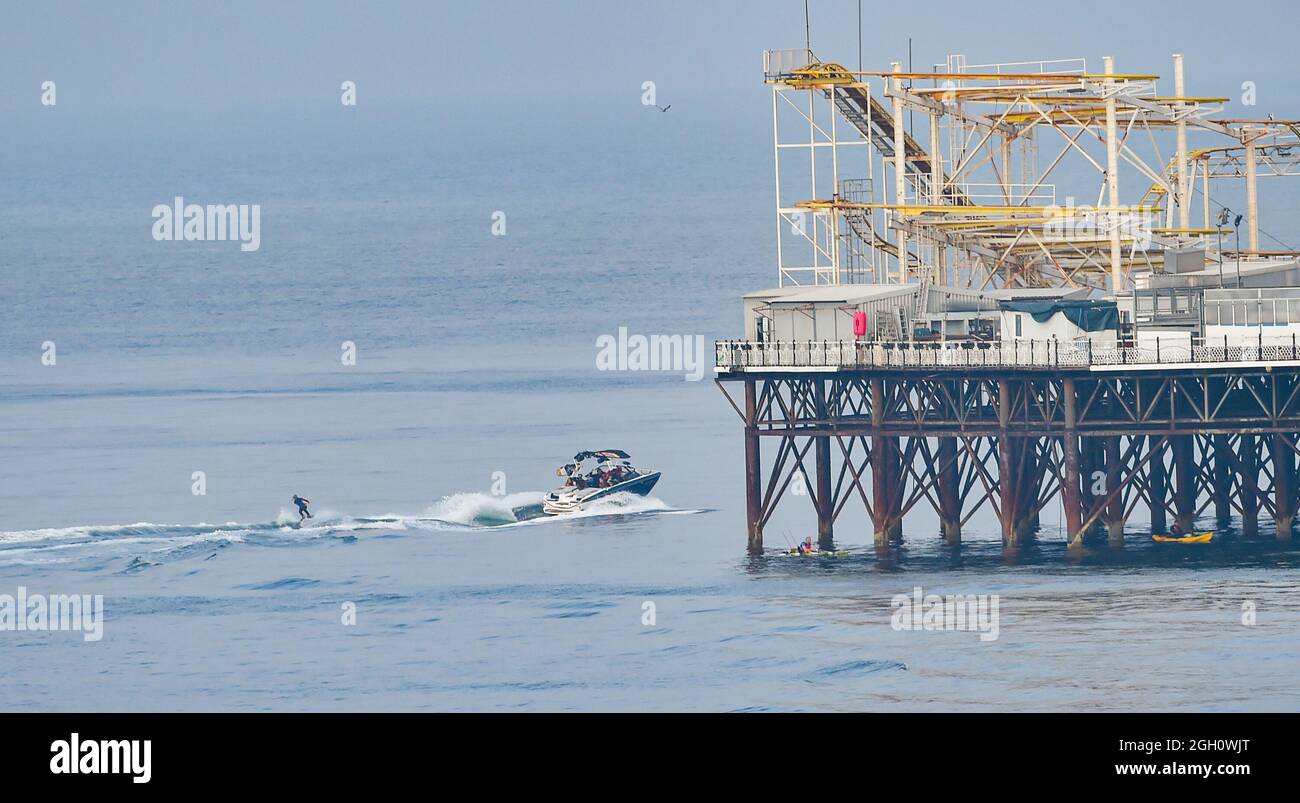 Brighton, UK. 4th September 2021 - A water skier makes the most of the hot sunny and calm conditions by Brighton Palace Pier as the weather is forecast to be hot and sunny over the next few days .  : Credit Simon Dack / Alamy Live News Stock Photo