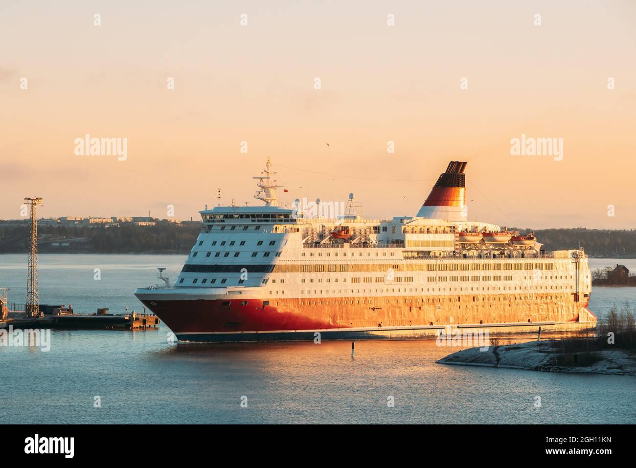 Helsinki, Finland. View Of Modern Ferry Ferryboat Floating Near Blekholmen Valkosaari Island At Sunrise Sky. Stock Photo