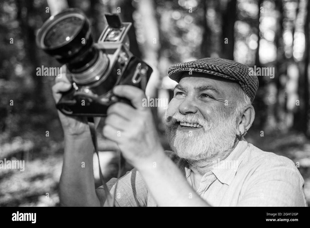 Manual settings. Pension hobby. Experienced and qualified photographer. Old man shoot in nature. Cameraman outdoors. Professional photographer Stock Photo