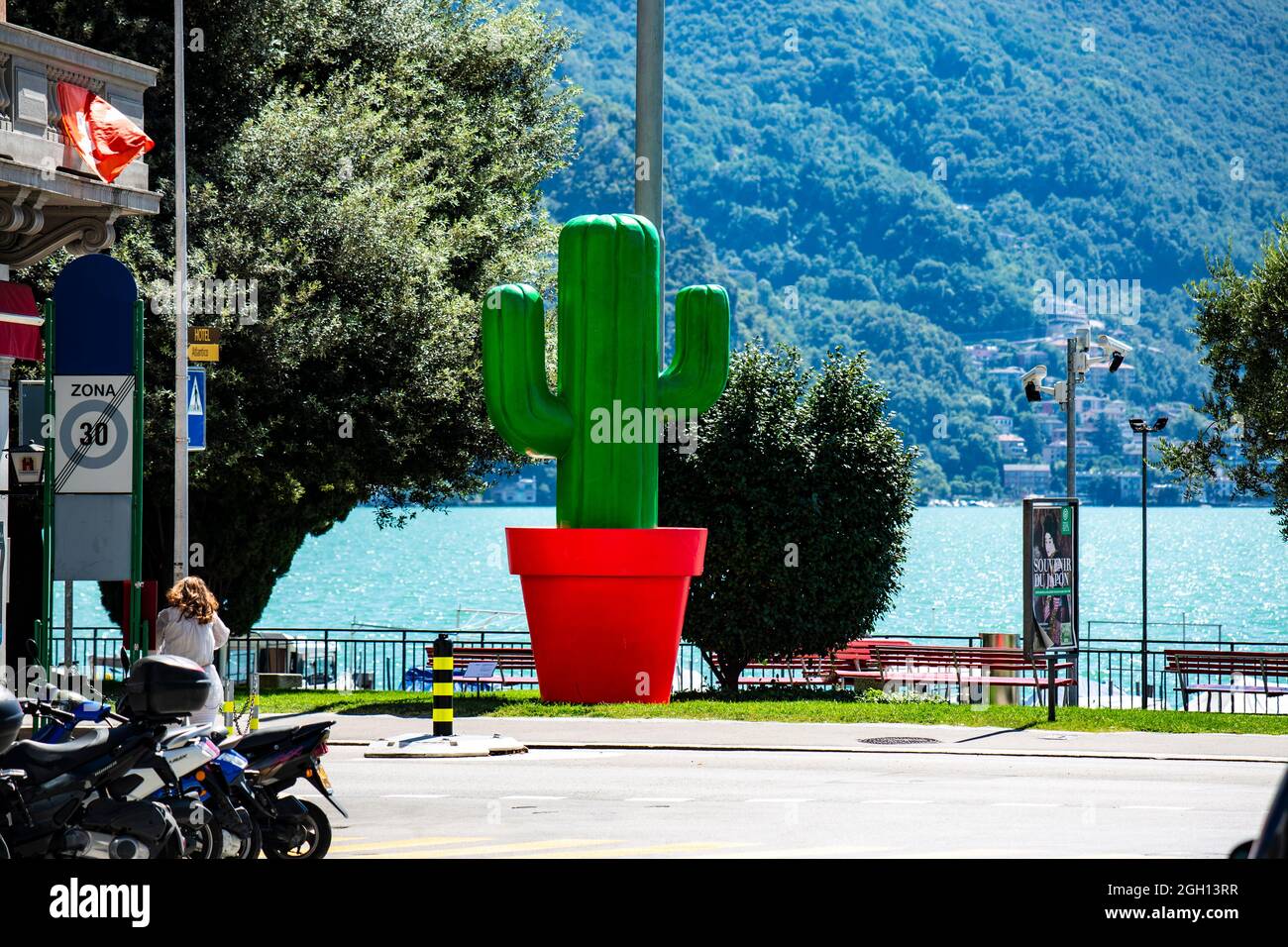 Ein großer grüner Kaktus in einem roten Topf in Lugano am Luganer See in der Schweiz. Stock Photo