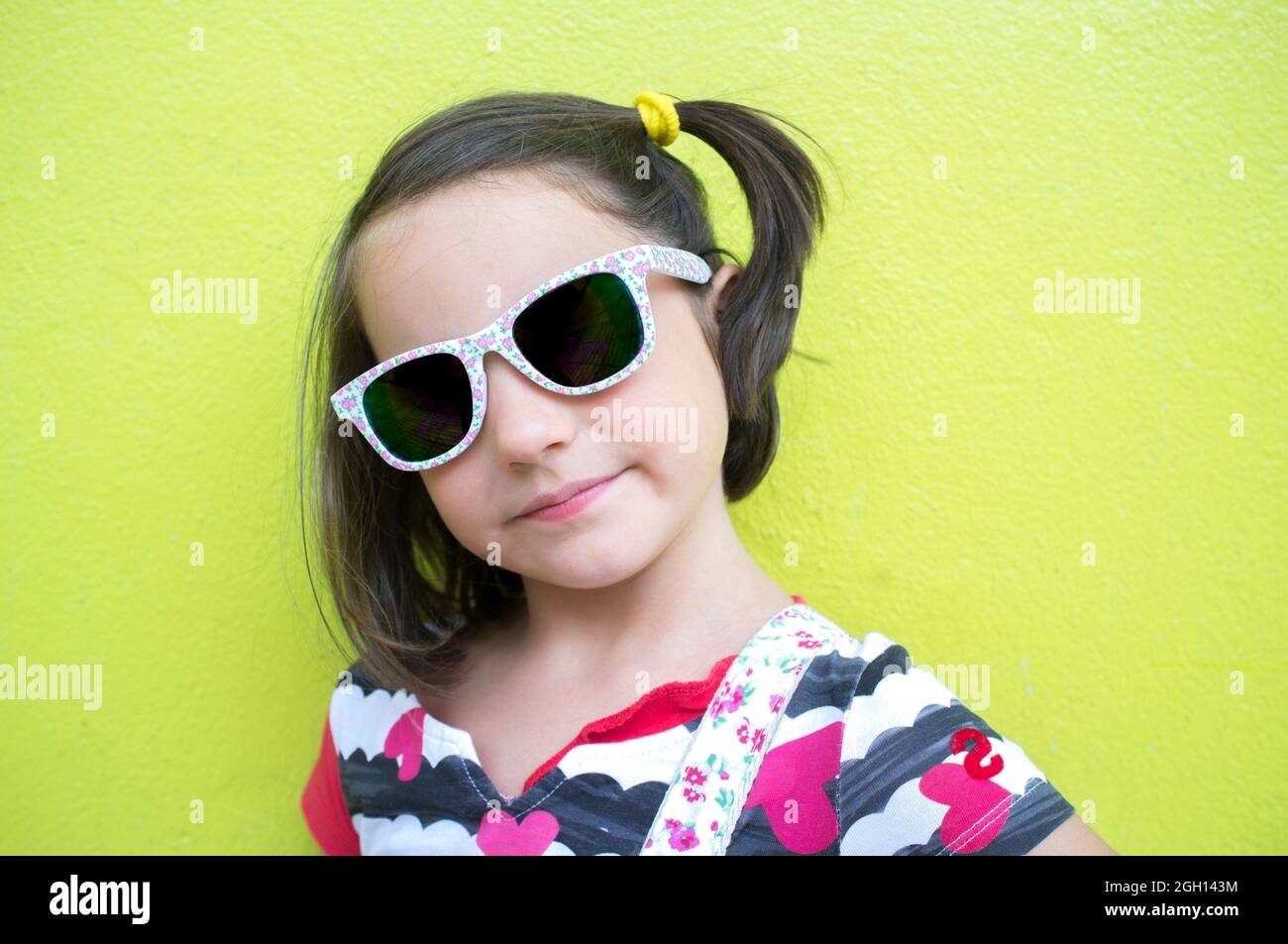 6 years old little girl with fashion dark sunglasses over green